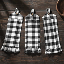 Three black and white checkered towels hanging on a wooden surface.