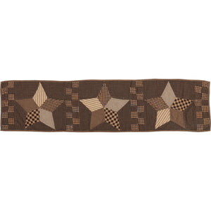 A brown quilted table runner featuring a rustic star pattern with beige and brown patchwork stars and checkered details, shown against a plain white background.