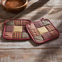 Pair of patchwork potholders on a wooden surface